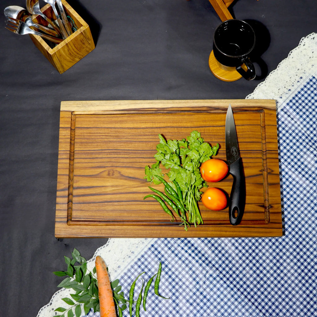 Wooden cutting board with vegetables and a knife on a checkered tablecloth
