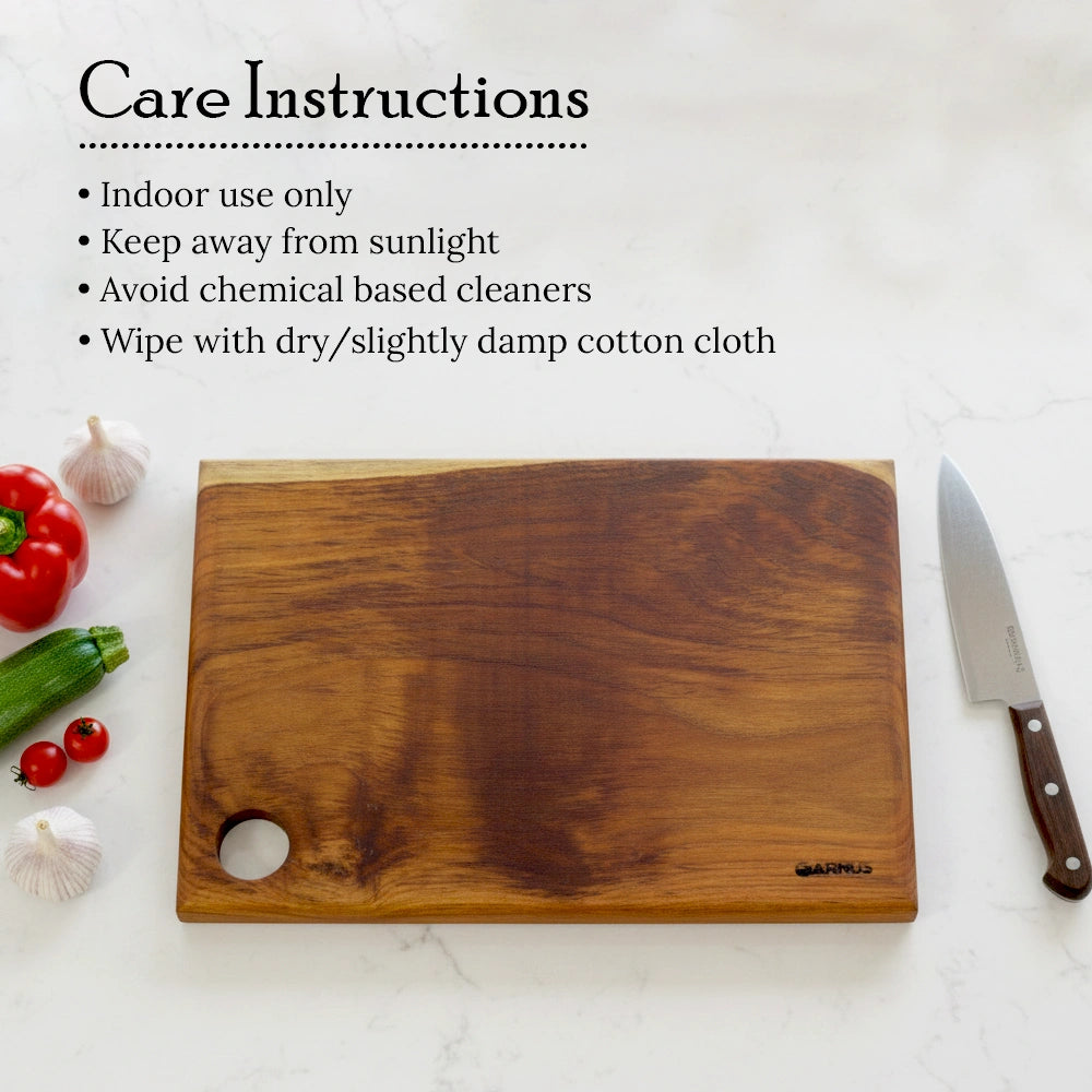 Wooden cutting board with knife and vegetables on a white surface, featuring care instructions.