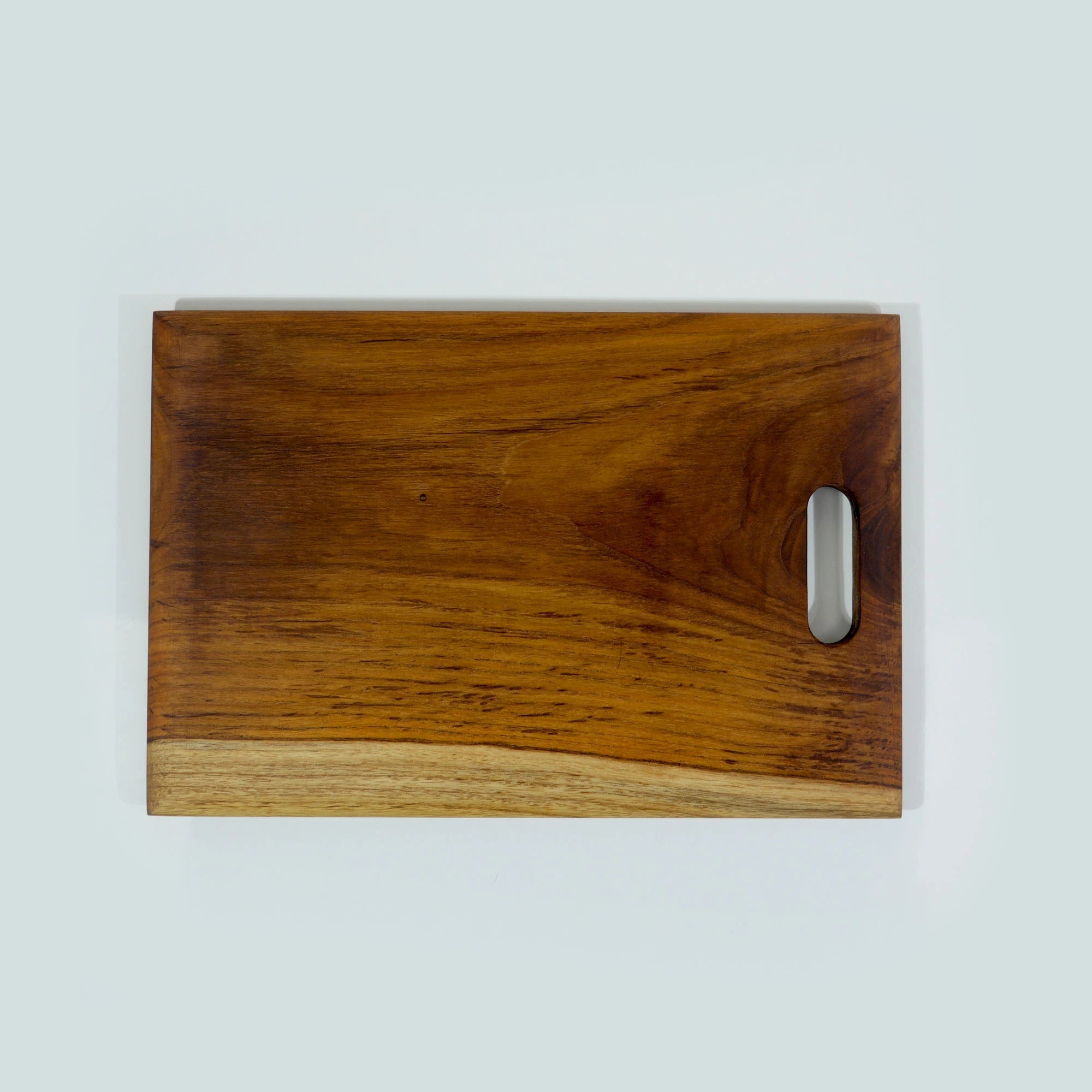 Organic Wooden chopping board with a handle on a light gray background