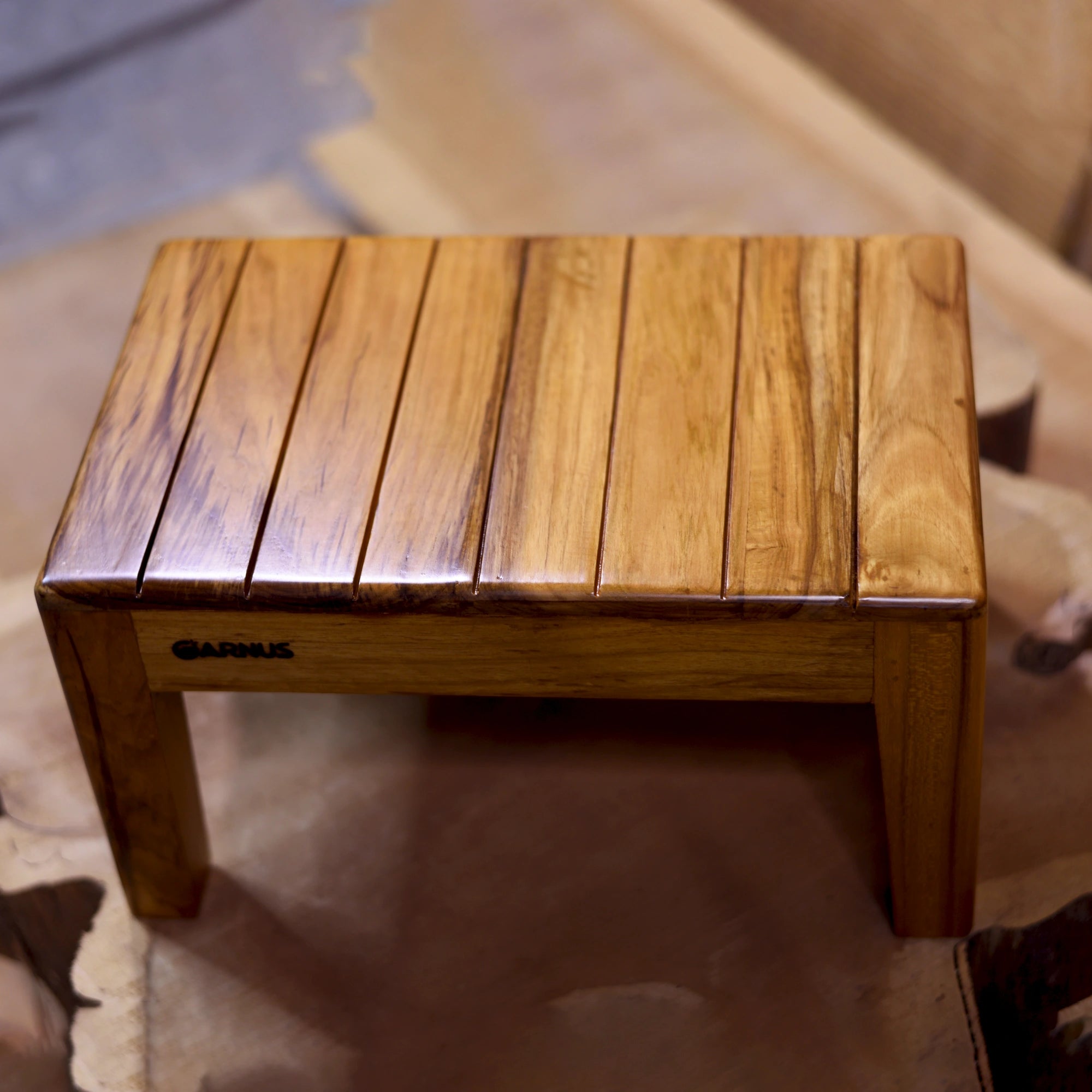Wooden step stool with 'Garnus' branding on a woden floor.