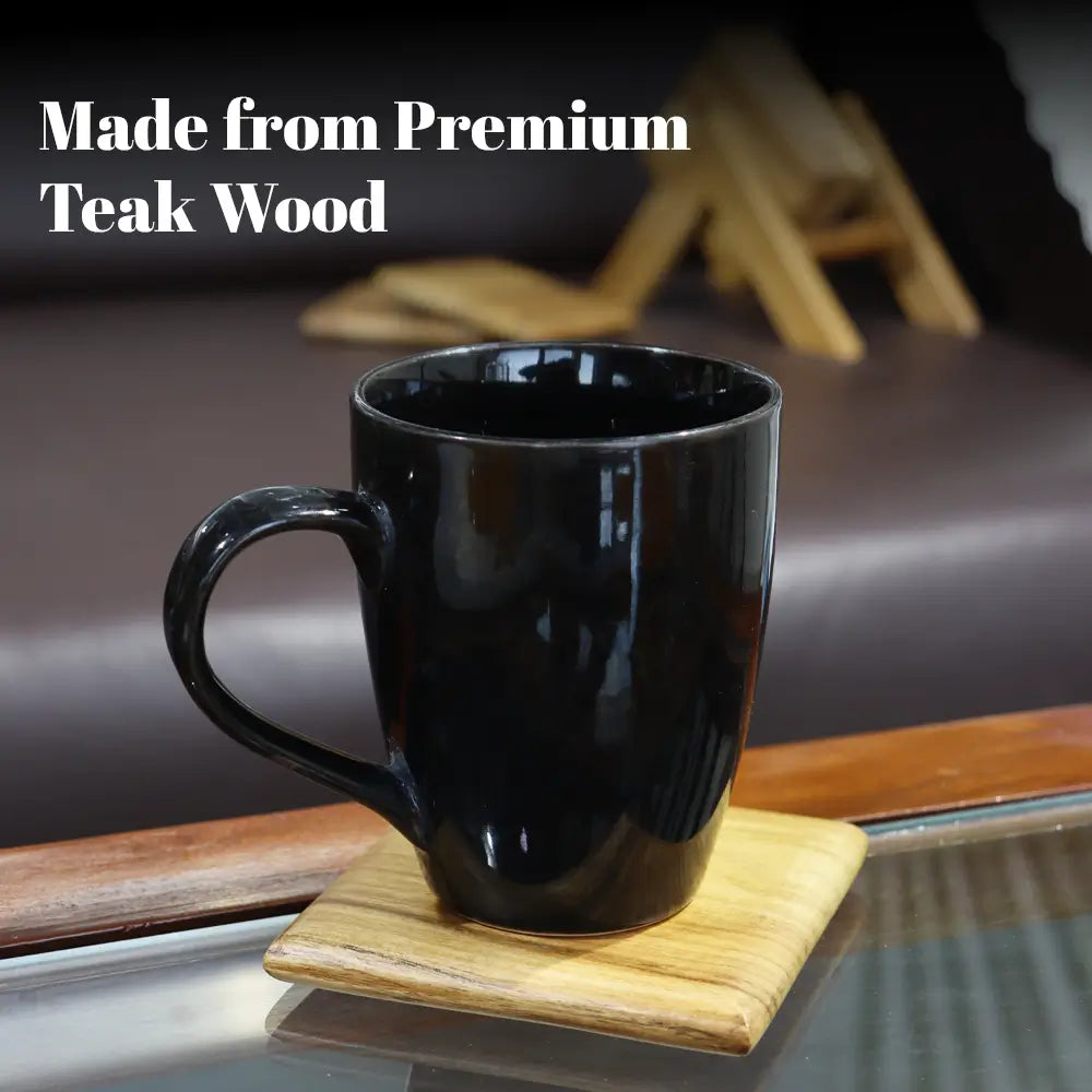Black mug on a wooden square coaster with text 'Made from Premium Teak Wood' in a blurred background.