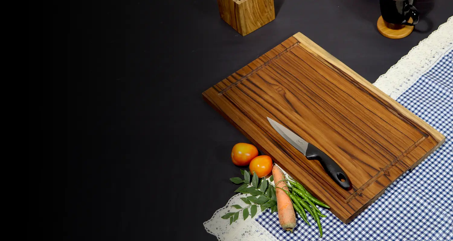 Wooden cutting board with a knife and vegetables on a checkered tablecloth