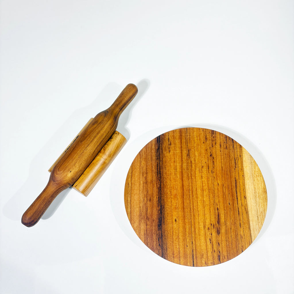 Wooden rolling pin and round wooden board on a white background