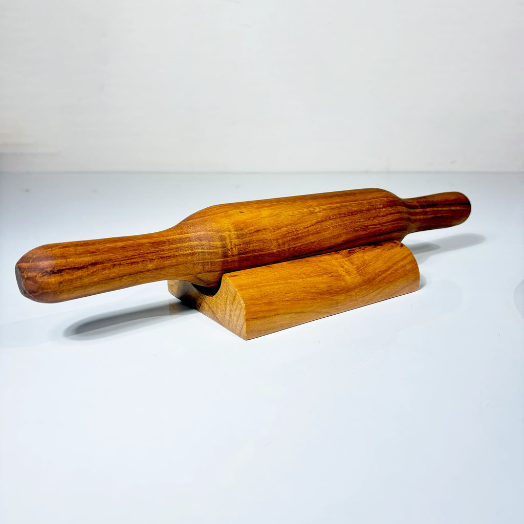 Wooden rolling pin on a wooden stand against a white background