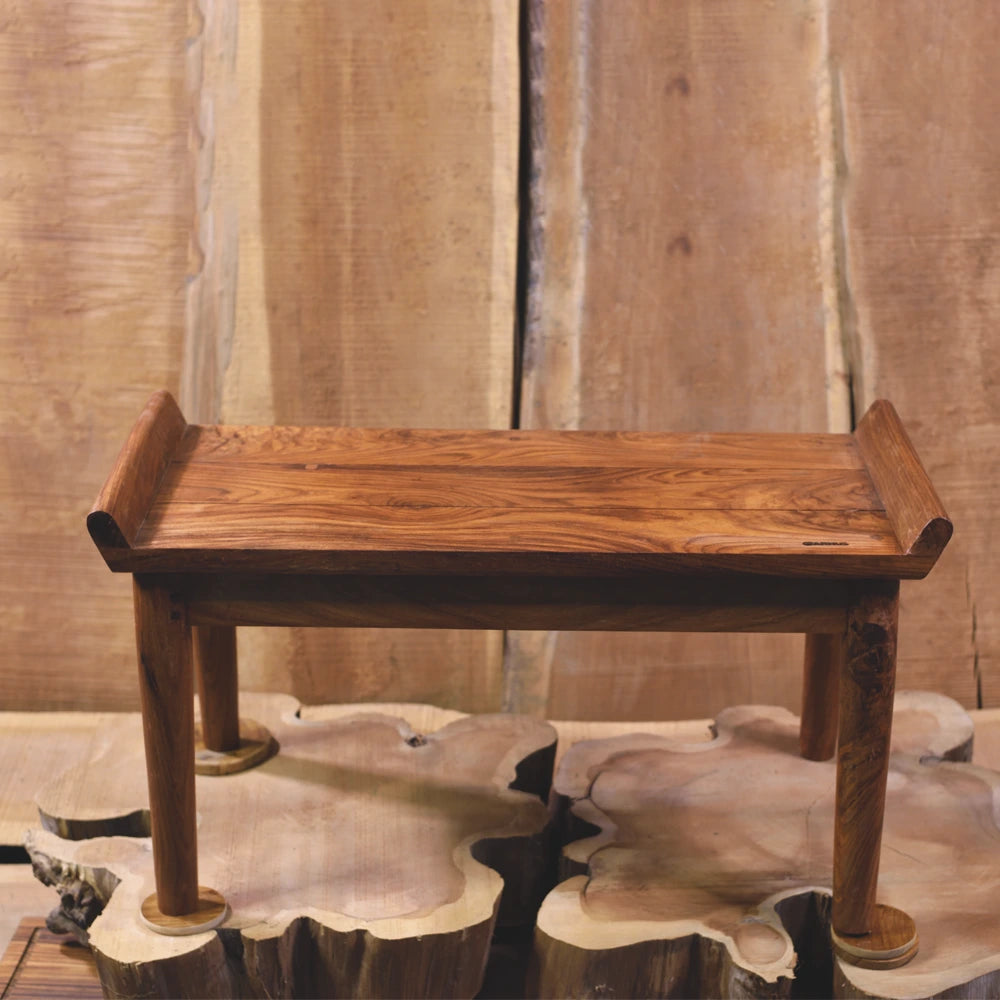 Wooden table on a decorative stone platform with a wooden panel background