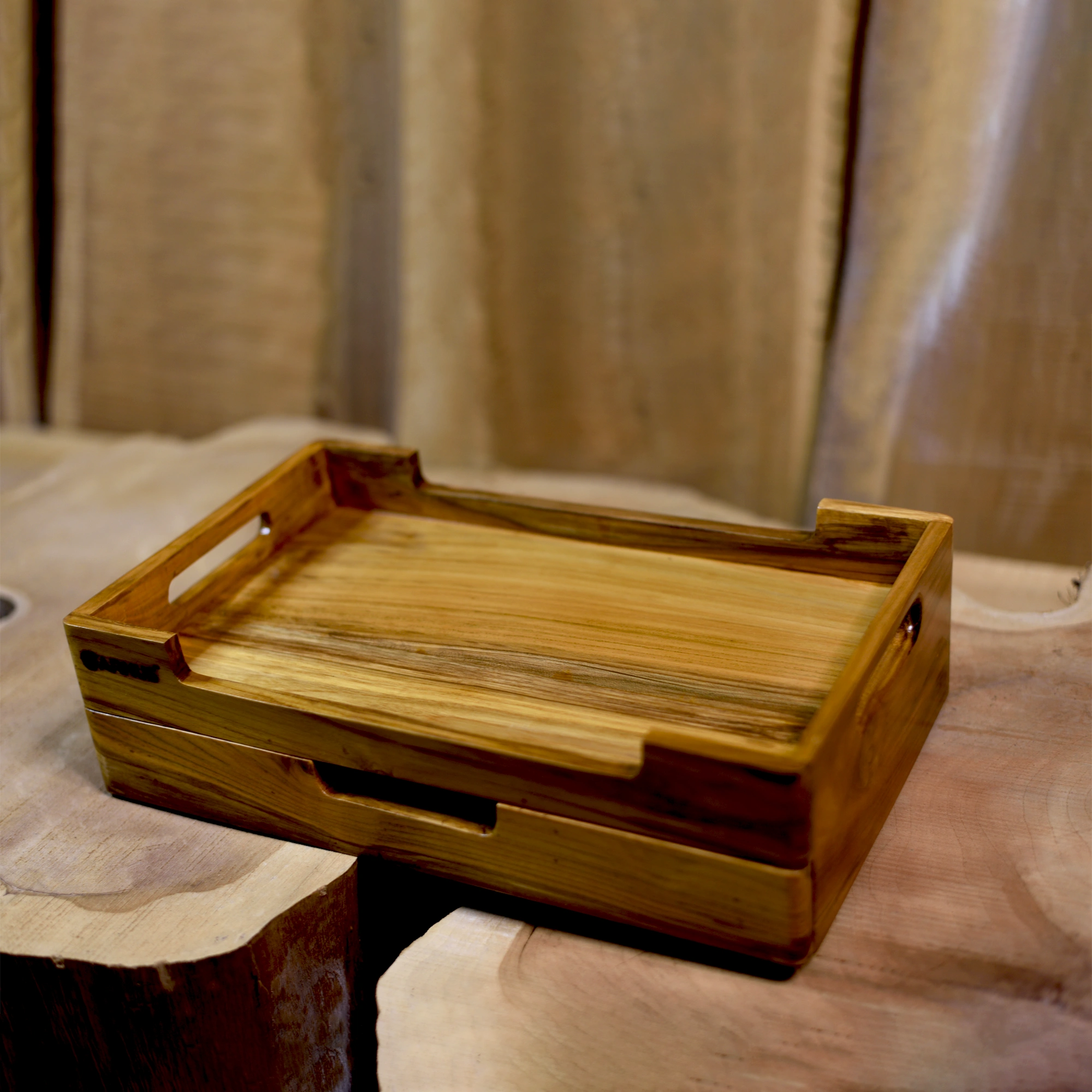 Wooden tray with handles on a textured surface