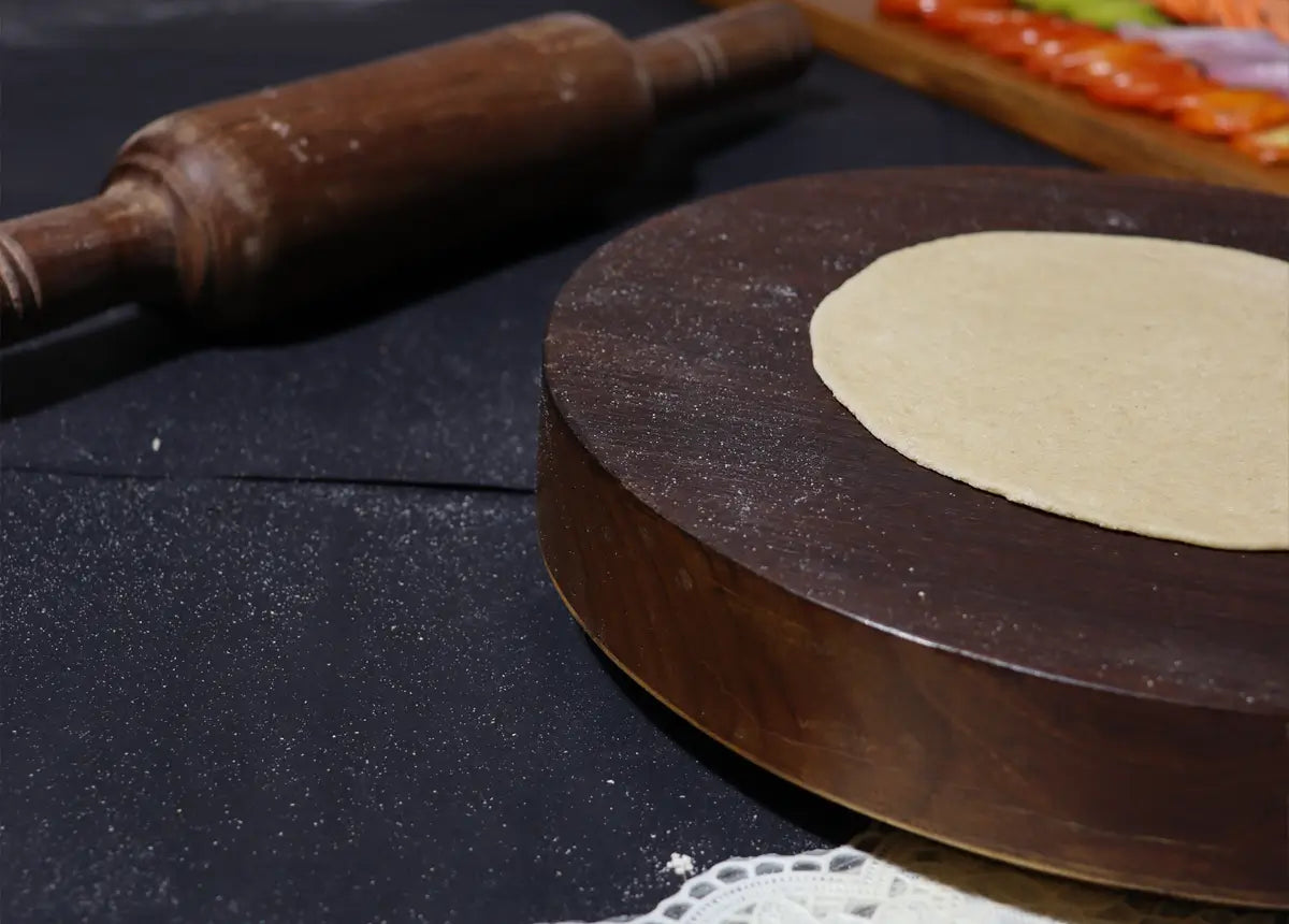 Rolled dough on wooden board with rolling pin
