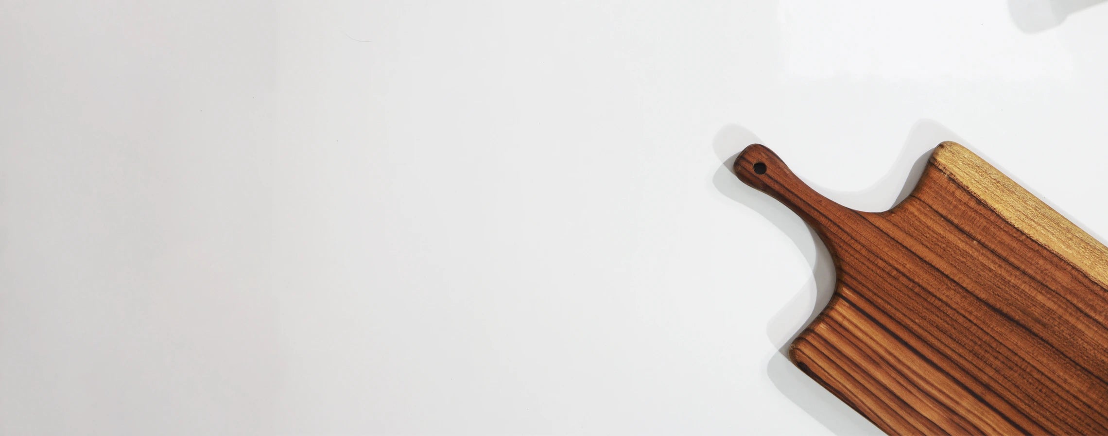 Wooden cutting board with a handle on a white background